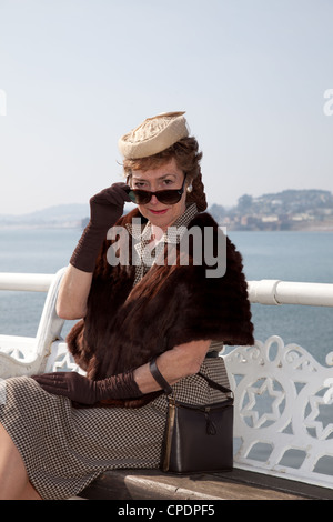 1940er Jahre gekleidete Frau auf Lage direkt am Meer Stockfoto