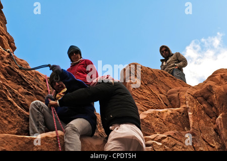 Wanderer mit Seil, steilen Felsen abzusteigen Gesicht Wadi Rum Jordan Stockfoto