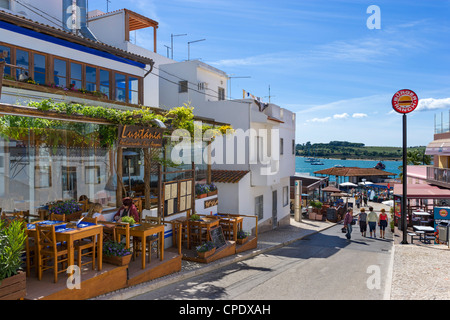Geschäfte und Bars im Zentrum des Resorts von Alvor mit Blick auf den Hafen, in der Nähe von Portimao, Algarve, Portugal Stockfoto