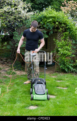 Kaukasischen Mann Rasenmähen im Garten in Bristol, Großbritannien Stockfoto