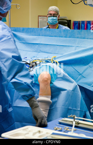 Orthopädischer Chirurg, die Vorbereitung der Patienten für arthroskopische Knieoperation in einer Krankenhaus-OP-Raum-suite Stockfoto