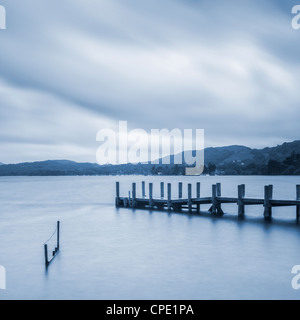 Ein ruhiger Morgen am Coniston Water im englischen Lake District, mit Steg und Zaun im Vordergrund. Stockfoto