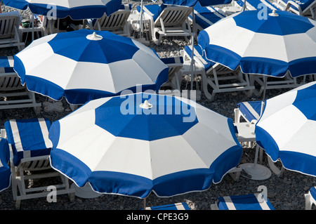 Sonnenschirme und Liegestühle Nizza Südfrankreich blickte auf Zeilen blau und weiß Stockfoto