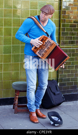 Porträt eines Straßenmusikers, der ein Akkordeon spielt, Columbia Road Flower Market, London, England, Großbritannien. Stockfoto