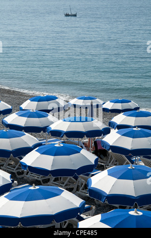 blickte auf Reihen von blauen und weißen Sonnenschirmen an der Küste schöne Südfrankreich Stockfoto