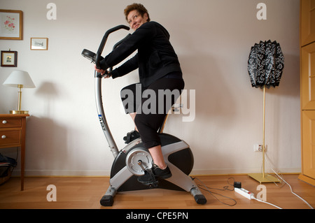 Frau zu Hause verwenden einen Heimtrainer Stockfoto