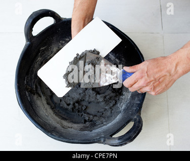 Contruction Maurer Arbeiter Hände mit Zement Mörtel Spachtel Eimer und Kelle Stockfoto