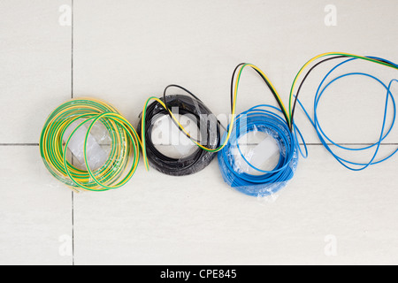 Elektrische Kabel Spule in drei Farben blau und grün gelb Schwarzerde Boden Stockfoto