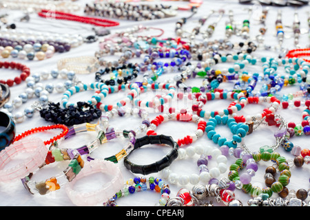 Schmuck, gemischt in einem Schnäppchenmarkt verteilt auf weißem Stoff Stockfoto