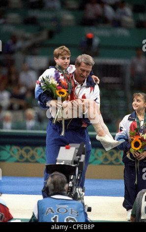 Bela Karolyi USA Coach trägt Kerri Strug (USA) mit den verletzten Knöchel auf die Präsentation der gold-Medaille Stockfoto