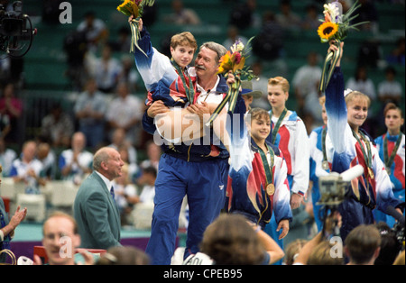 Bela Karolyi USA Coach trägt Kerri Strug (USA) mit den verletzten Knöchel auf die Präsentation der gold-Medaille Stockfoto