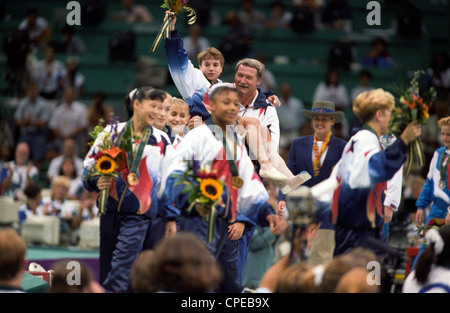 Bela Karolyi USA Coach trägt Kerri Strug (USA) mit den verletzten Knöchel auf die Präsentation der gold-Medaille Stockfoto