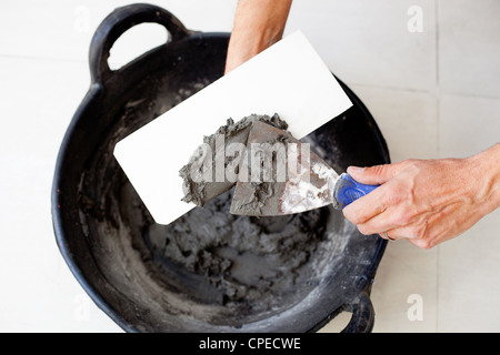 Contruction Maurer Arbeiter Hände mit Zement Mörtel Spachtel Eimer und Kelle Stockfoto