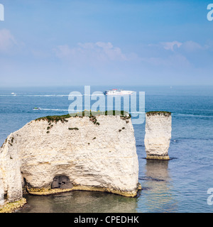 Der alte Harry Felsen in der Nähe von Swanage in Dorset, England, mit einer Katamaran-Schnellfähre und andere Boote im Hintergrund. Stockfoto