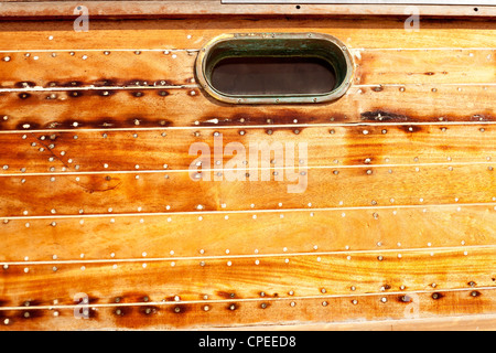 Boot-Oval im Alter Messing Bullauge in Holzrumpf mit Putty und Schraube das Abdichten Stockfoto