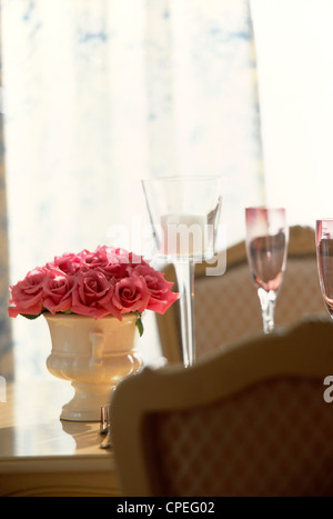Rosa Rosen In Vase auf Esstisch Stockfoto