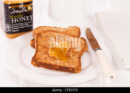 Manuka Honig, eine Spezialität von Neuseeland, ist bekannt für seine antibakterielle und heilenden Eigenschaften. Es ist sehr lecker auf Toast! Stockfoto