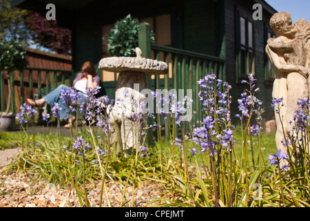 Frau liest eine Kindle e-Reader saßen draußen ihr Sommerhaus in voller Sonne. Stockfoto