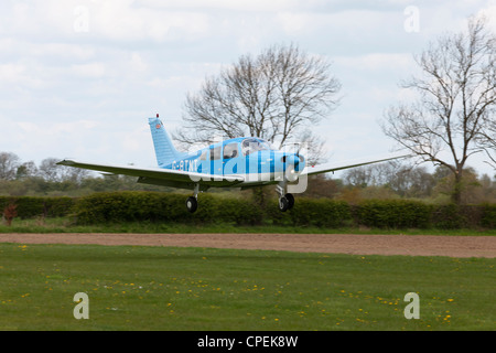 Piper pA-28-160 Cherokee Krieger G-BTNT Landung am Breighton Flugplatz Stockfoto