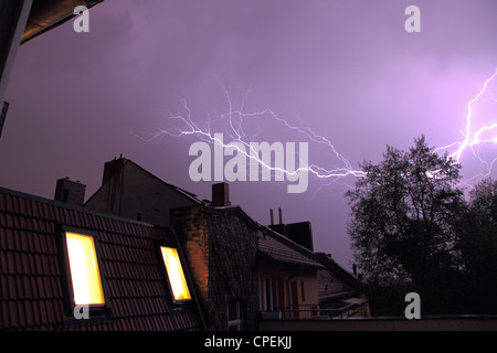 Gewitter mit Blitzen über den Dächern von Reihenhäusern Stockfoto