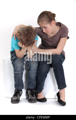 Schwester ihren kleinen Bruder zu trösten. Stockfoto