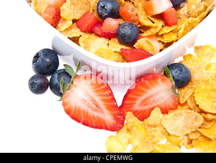 Cornflakes mit frischen Früchten in eine Schüssel geben, die isoliert auf weißem Hintergrund Stockfoto