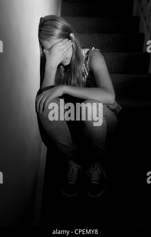 Junge Mädchen sitzen auf dunklen Treppen wieder anzeigen Stockfoto