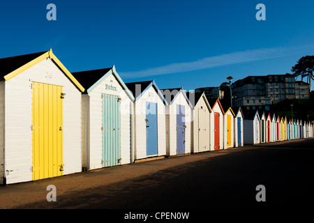 Bunten Badekabinen gegen den blauen Himmel am frühen Morgen die Sonne. Goodrington, Paignton, Devon, England Stockfoto