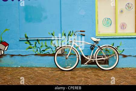 Ein altes weißes Fahrrad eine blaue Wand gelehnt Stockfoto