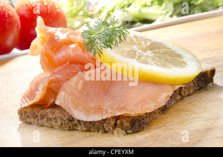 Geräucherte Lachsscheiben mit Zitrone auf Roggenbrot Stockfoto