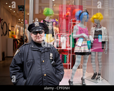 Ein Polizist steht vor einem Schaufenster in New York City. Stockfoto