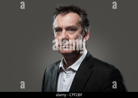 Kopf geschossen Porträt der schönen Mittelalter Geschäftsmann im Anzug grau hinterlegte kontrastreiche Grunge-Look Stockfoto