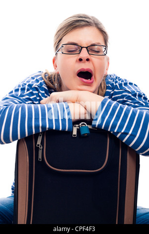 Müde Reisende Tourist Frau Gähnen auf Gepäck, isoliert auf weißem Hintergrund. Stockfoto