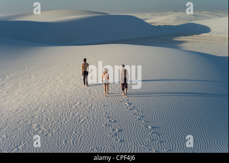 Drei Menschen, die zu Fuß in Wellen im Sand, White Sands National Monument, New Mexico, USA Stockfoto