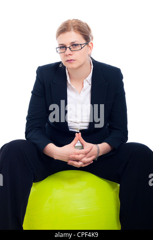 Zuversichtlich ernste nachdenklich Geschäftsfrau sitzen auf grün Gymnastikball, isoliert auf weißem Hintergrund. Stockfoto