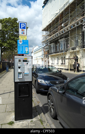 Bezahlung der Parkautomat neben Straße mit Autos geparkt Stockfoto