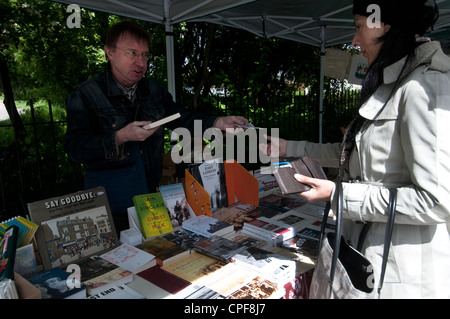 Goldschmied Zeile Hackney. Sonntagmorgen Buchmarkt. Frau stall, ein Buch zu kaufen und Übergabe Geld in Brick Lane Buchhandlung Stockfoto