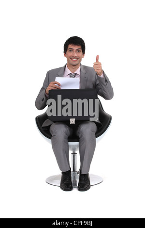 sitzenden jungen Geschäftsmann mit Daumen Stockfoto