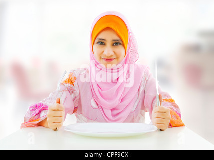 Muslimischen ein und leeren Nahrung für Gabel Messer Teller bereit Restaurant mit Frau halten Stockfoto