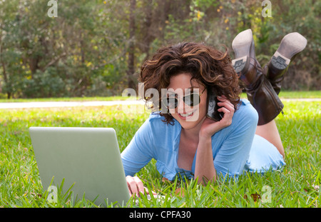Junge attraktive Woamn Alter 25 vor Haus im Hof, e-Mail und sprechen auf Zelle, um Freunde mit Sonnenbrille und modernen look Stockfoto