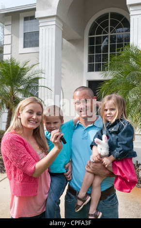 Familie mit zwei kleinen Kindern Umzug teuer mit Schlüsseln von Immobilien des amerikanischen Traums Stockfoto