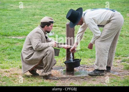 Zwei Soldaten der Konföderiertenarmee füllen Sie Wasser aus Straße Wasserhahn, War Reenactment, Bensalem, USA Stockfoto