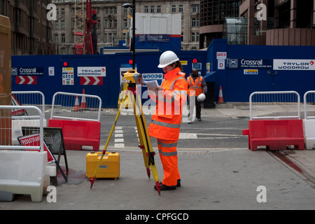 Eine junge Ingenieurin mit Surverying Geräten arbeiten an Crossrail Eisenbahn Ouside Liverpool Street Station London England UK KATHY DEWITT Stockfoto