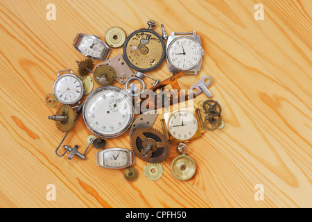 Armbanduhren, Stoppuhr und Uhr Teile liegen auf einer Holzoberfläche Stockfoto