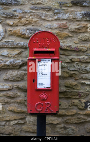 Eine alte rote Briefkasten mit einer steinernen Mauer Stockfoto