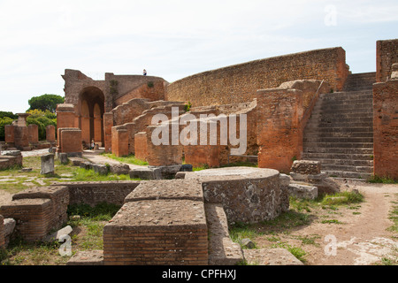 Das Theater und die Spalten aus der Decumanus auf die römischen Hafen-Stadt-Ruine von Ostia bei Rom. Stockfoto