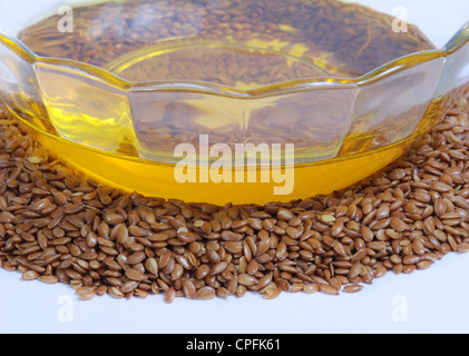 Leinöl in Schale und ganze Leinsamen. Isoliert auf weiss. Stockfoto