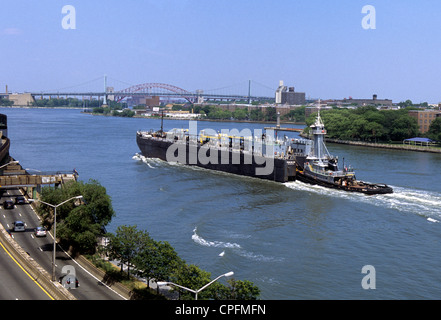 Schlepper und Ölscow oder Tanker-Barge auf dem East River, New York City, FDR Drive. Robert F Kennedy Bridge Hell Gate Bridge im Hintergrund. USA Stockfoto