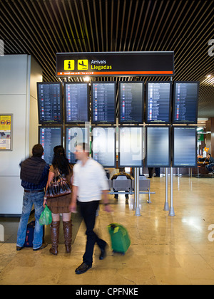 Personen an Zeitplan Flugtafel am Flughafen Barajas in Madrid, Spanien Stockfoto