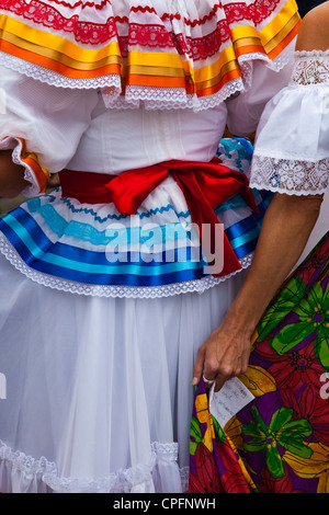 Zwei mexikanische Frauen in traditioneller Kleidung und eine hält einen Hinweis Stockfoto